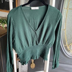 dark green top with ruffled sleeves around wrist